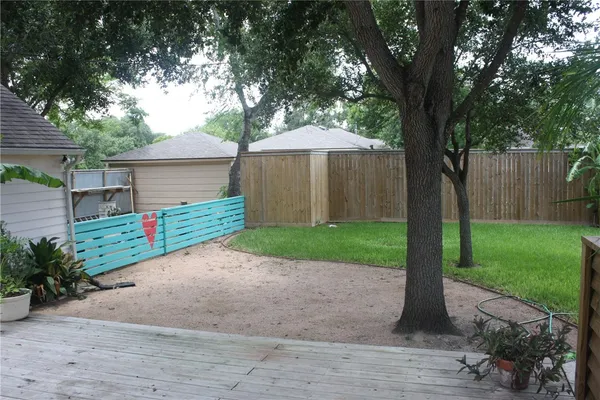 a view of a house with a yard and large tree