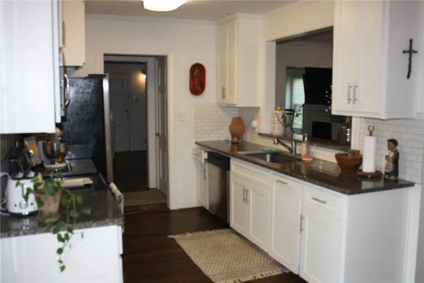 a kitchen with stainless steel appliances a sink stove and cabinets
