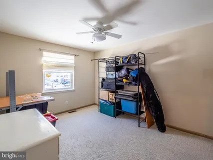 a bedroom with a bed a chandelier and a dresser