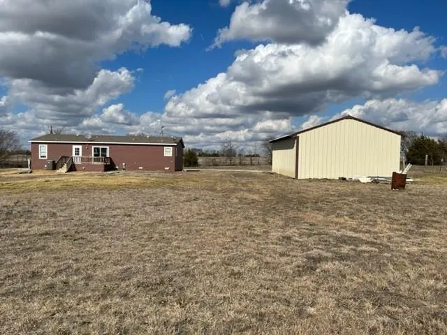 a view of a house with a big yard and a large tree