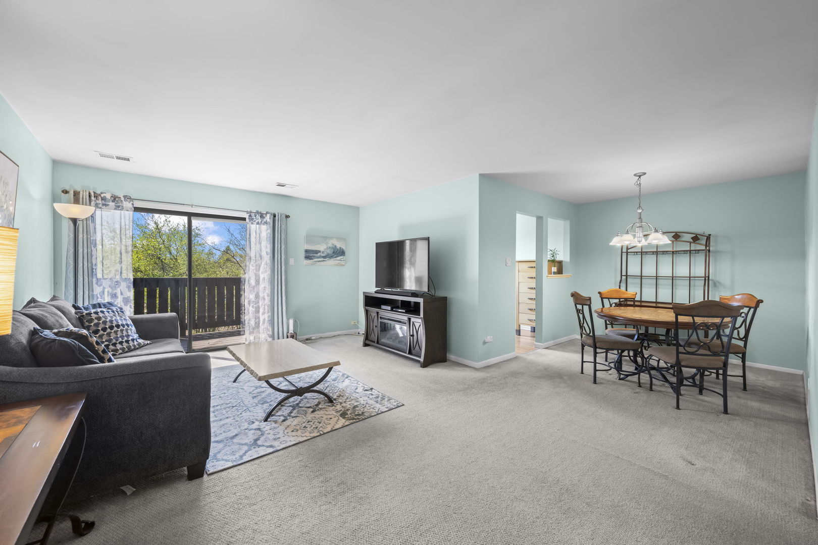831 Coach Road, Unit 4 Palatine, IL 60074 - Photo 2 of 18 a living room with furniture and a dining table with floor to ceiling window