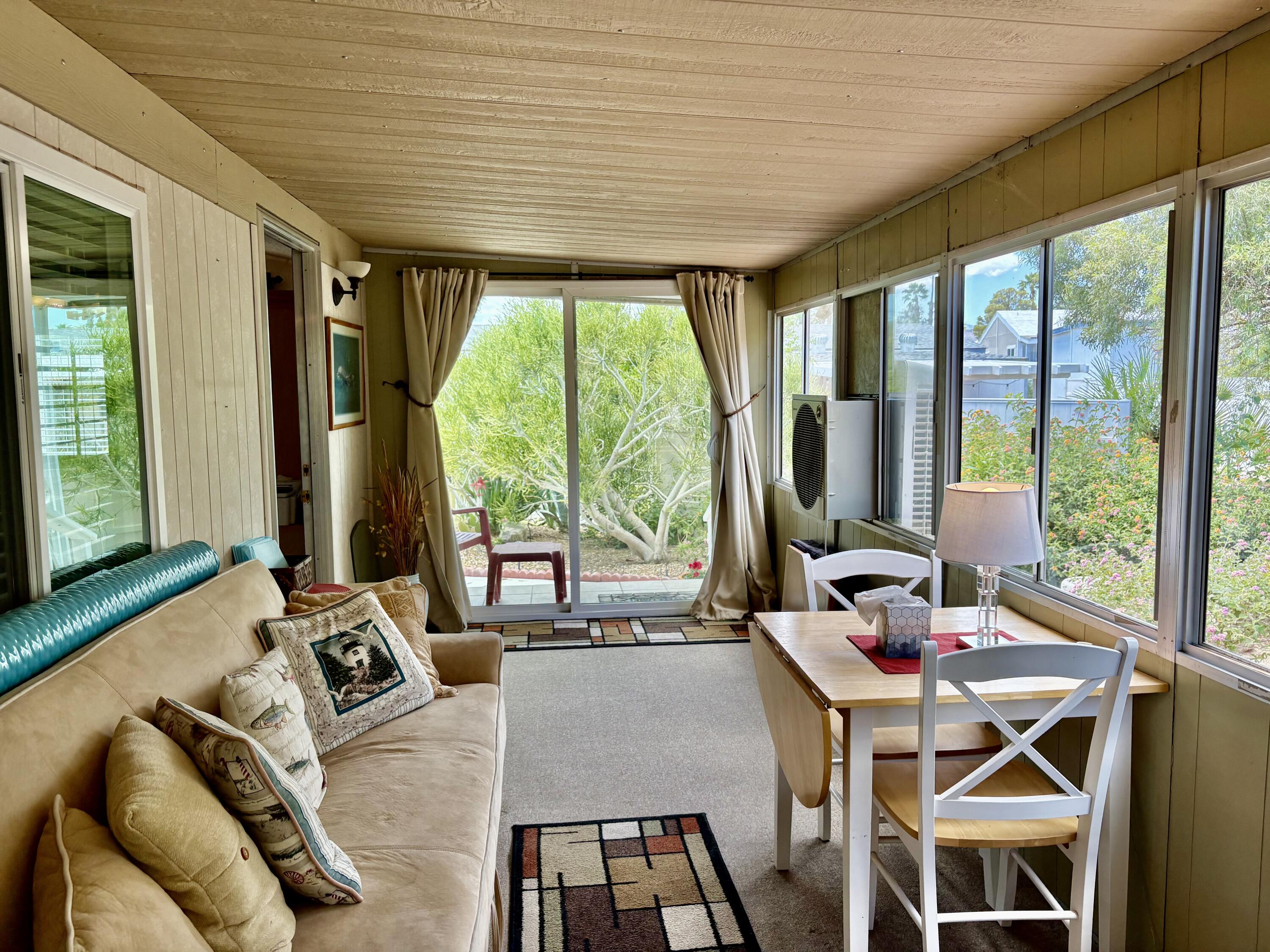 74711 Dillon Road, Unit 635 Desert Hot Springs, CA 92241 - Photo 20 of 55 a view of a dining room with furniture large windows and wooden floor