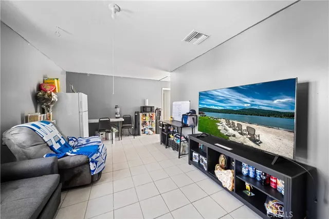 a living room with furniture a flat screen tv and a floor to ceiling window