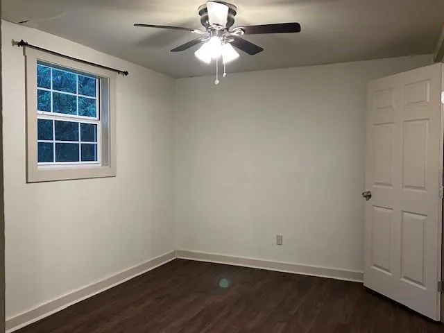 an empty room with a window and wooden floor
