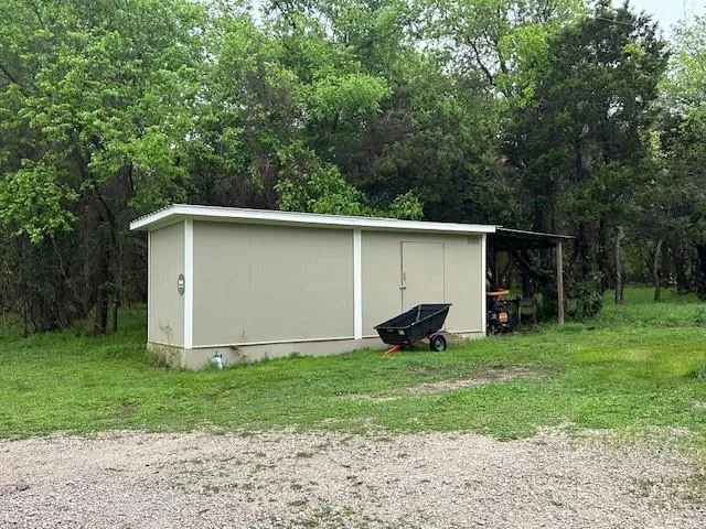 a view of backyard with small cabin and entertaining space