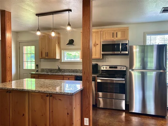 a kitchen with kitchen island a sink appliances and cabinets
