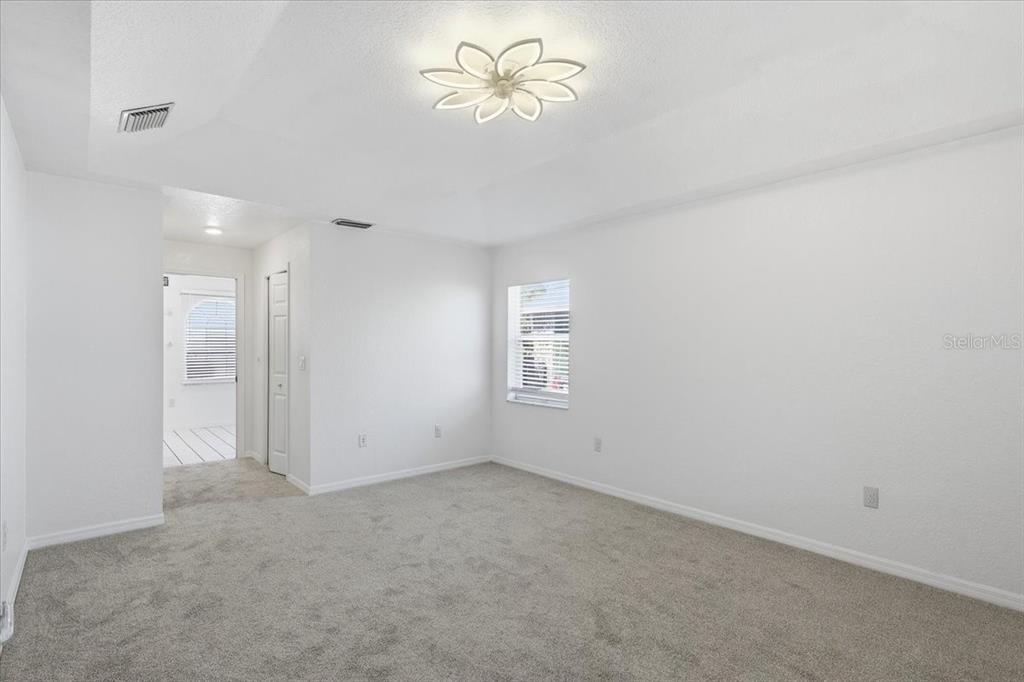 30 Patuxent Lane Palm Coast, FL 32164 - Photo 13 of 34 an empty room with a chandelier fan and windows