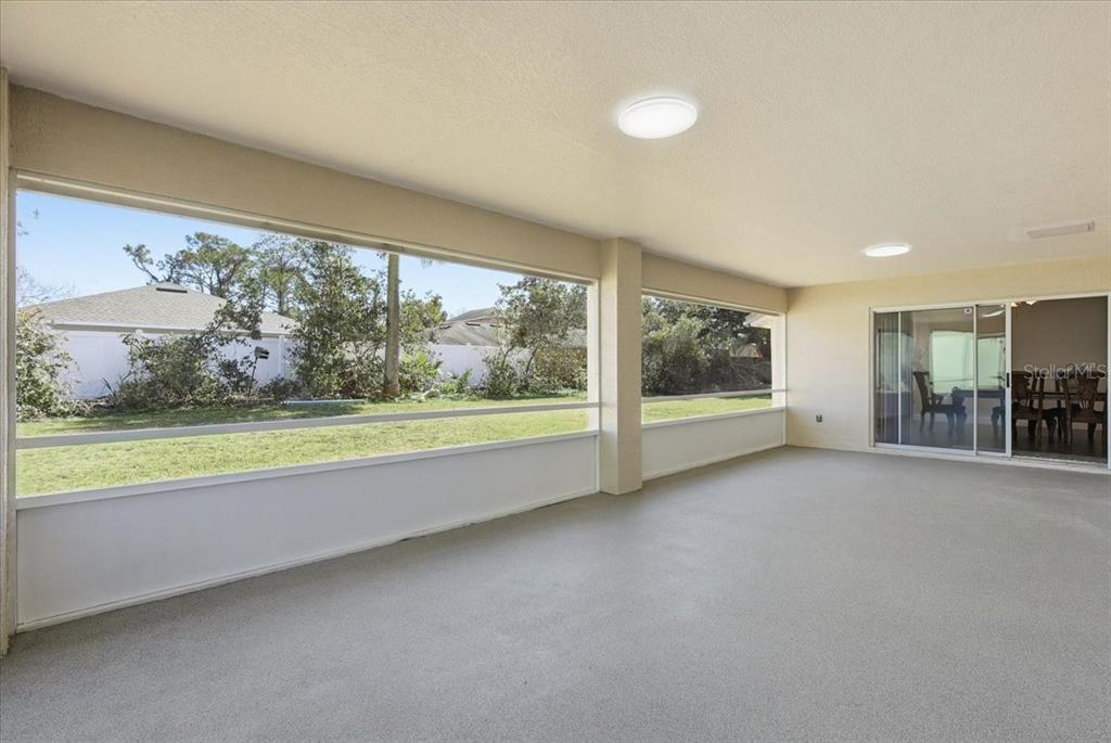 30 Patuxent Lane Palm Coast, FL 32164 - Photo 25 of 34 an empty room with floor to ceiling windows and garden view