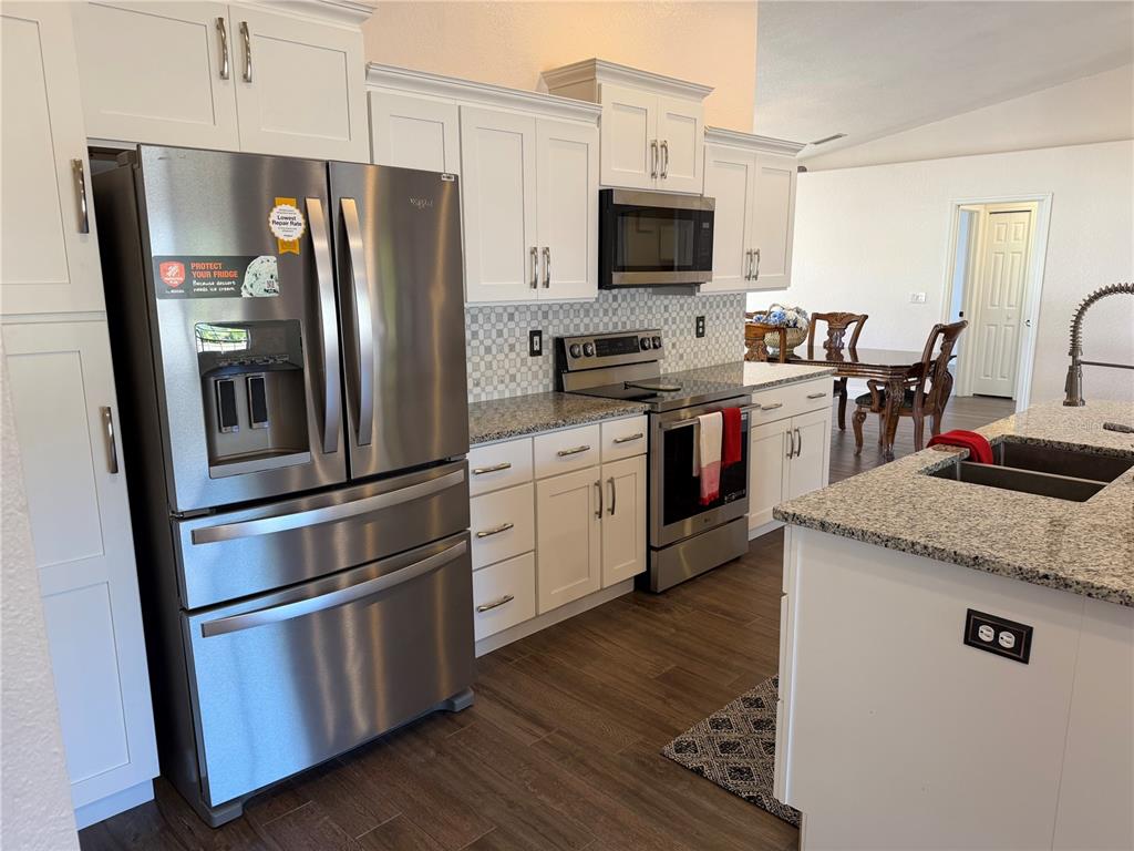 30 Patuxent Lane Palm Coast, FL 32164 - Photo 3 of 34 a kitchen with stainless steel appliances and wooden cabinets