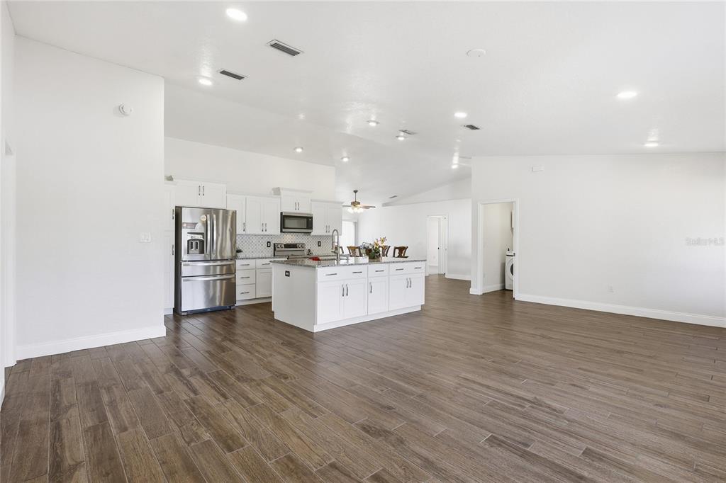 30 Patuxent Lane Palm Coast, FL 32164 - Photo 5 of 34 a large white kitchen with cabinets and wooden floor