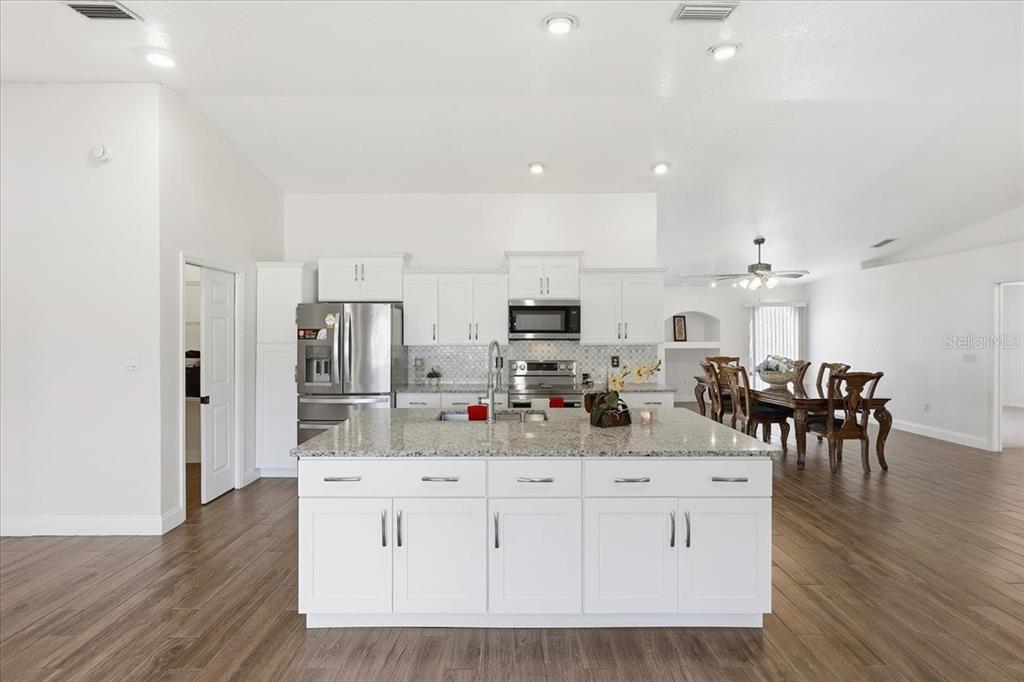 30 Patuxent Lane Palm Coast, FL 32164 - Photo 6 of 34 a kitchen with stainless steel appliances kitchen island granite countertop a refrigerator and cabinets