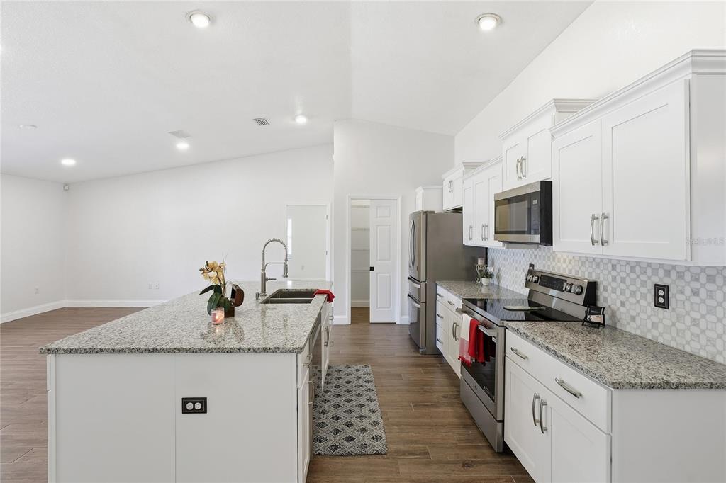 30 Patuxent Lane Palm Coast, FL 32164 - Photo 9 of 34 a kitchen with stainless steel appliances granite countertop a sink a stove and a refrigerator