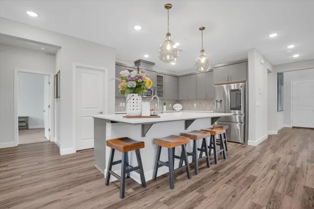 a view of a dining room and livingroom with furniture wooden floor a chandelier