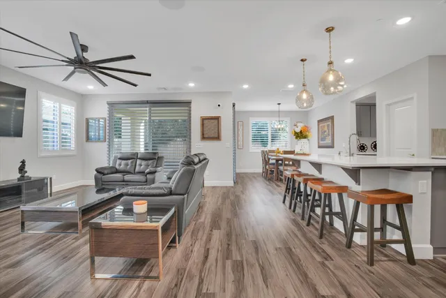 a living room with furniture a dining table and wooden floor