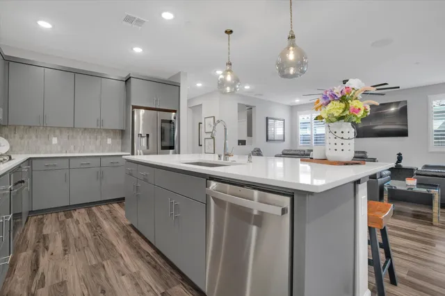 a kitchen with kitchen island granite countertop a sink cabinets and stainless steel appliances
