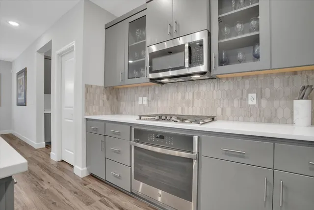 a kitchen with stainless steel appliances granite countertop a sink and a microwave