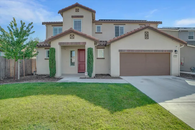 a front view of a house with a yard and garage
