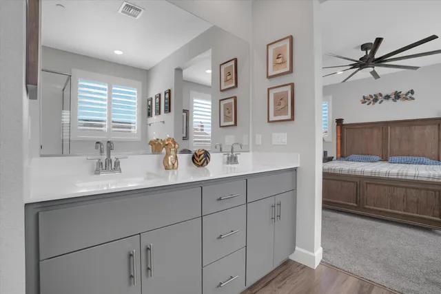 a bathroom with a granite countertop double vanity sink a mirror and a bathtub