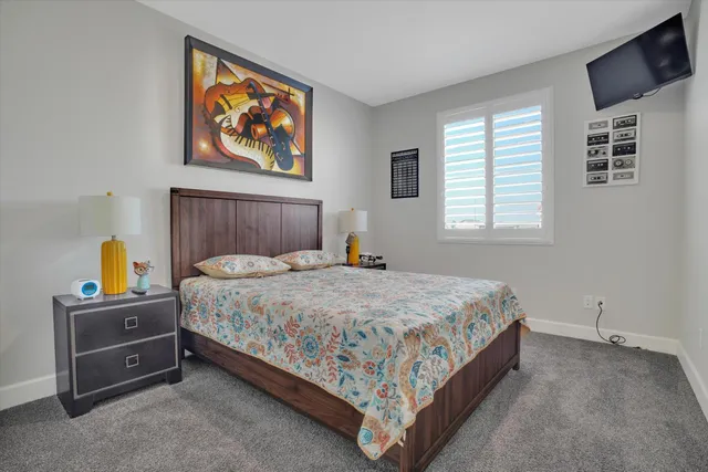 a bedroom with a bed and a tv on the dresser