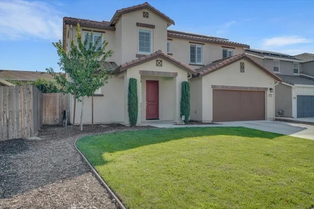 a front view of a house with a garden and yard