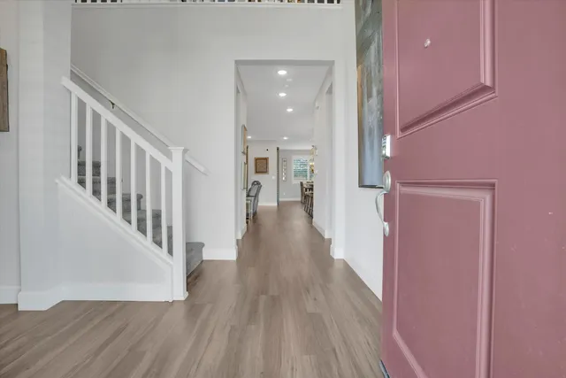 a view of a hallway with wooden floor and staircase