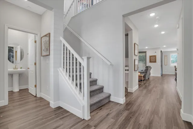 a view of a hallway with wooden floor and staircase