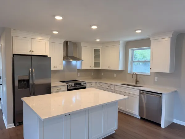 a kitchen with a sink a counter top space stainless steel appliances and cabinets
