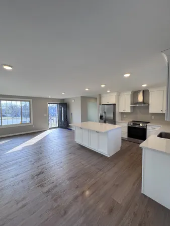a view of kitchen with kitchen island sink and wooden floor