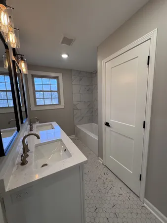a bathroom with a sink a toilet a mirror and shower