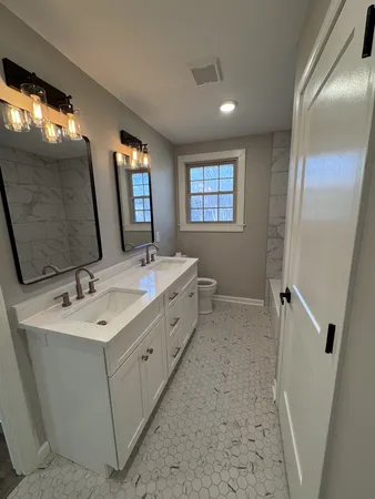 a spacious bathroom with a double vanity sink and a mirror