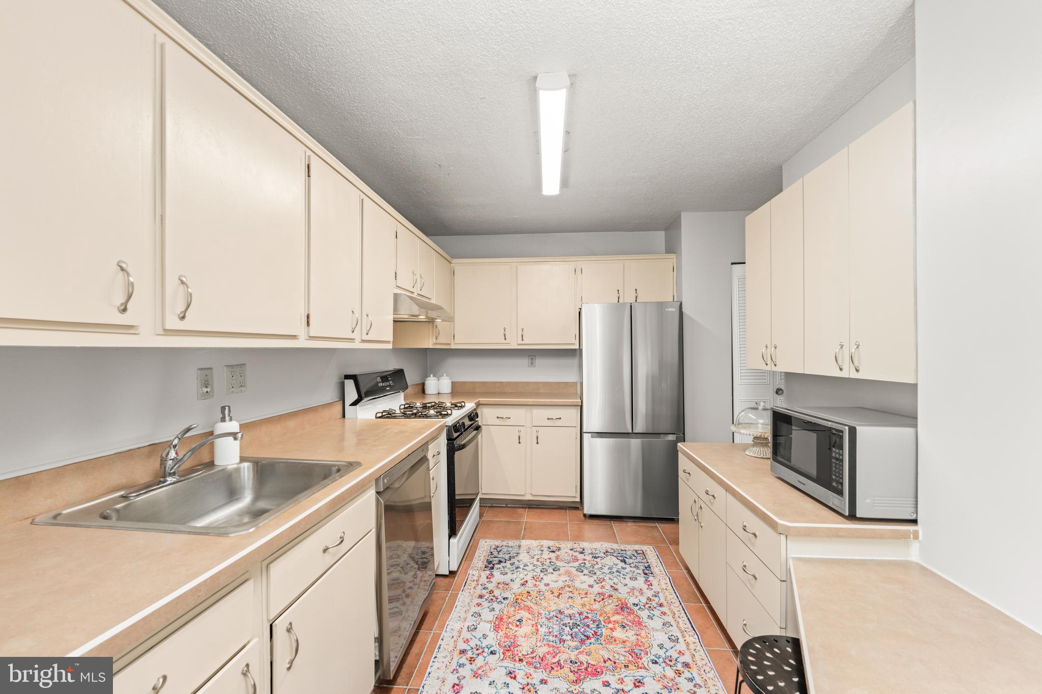 4401 Roland Avenue, Unit 115 Baltimore, MD 21210 - Photo 24 of 54 a kitchen with a sink stove and refrigerator