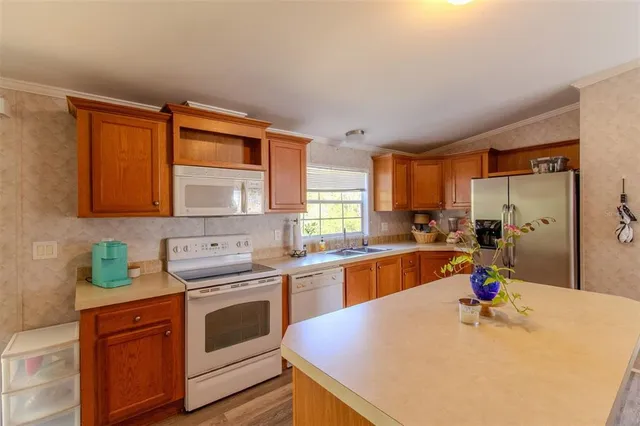 a open kitchen with stainless steel appliances granite countertop a sink stove and refrigerator