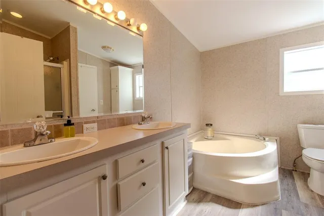 a bathroom with a double vanity sink a mirror and a toilet