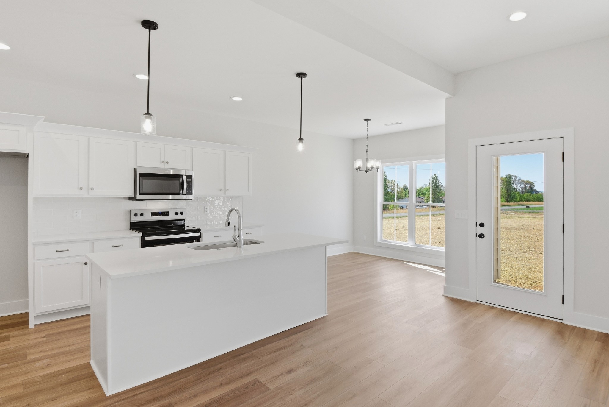 4335 Bybee Branch Road McMinnville, TN 37110 - Photo 7 of 25 a kitchen with stainless steel appliances a stove top oven a refrigerator a sink and dishwasher with wooden floor
