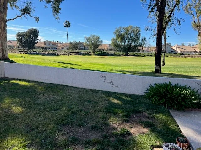 a view of a swimming pool with a yard and palm trees