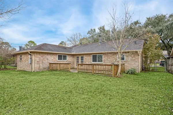 a view of a house with a big yard and large trees