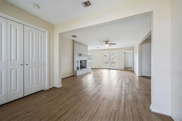 a view of empty room with wooden floor