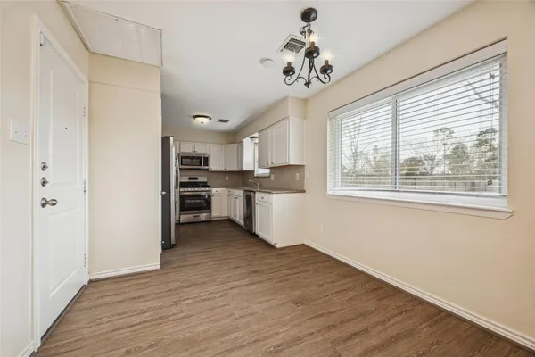 a view of kitchen with wooden floor and electronic appliances