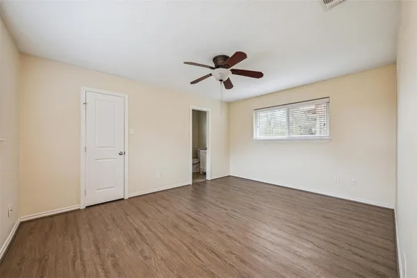 a view of room with wooden floor and ceiling fan