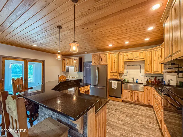 a kitchen with stainless steel appliances granite countertop a sink a stove and refrigerator