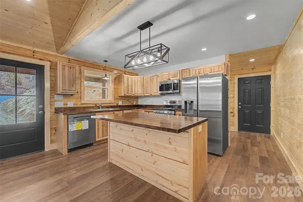 a kitchen with granite countertop wooden floors stainless steel appliances and cabinets