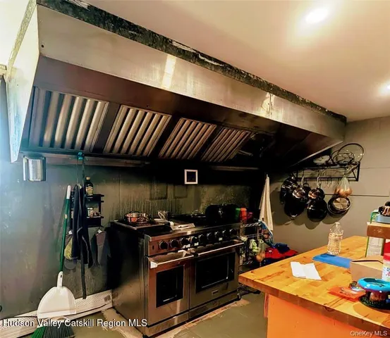 a view of patio with table and chairs under an umbrella with barbeque grill and wooden fence