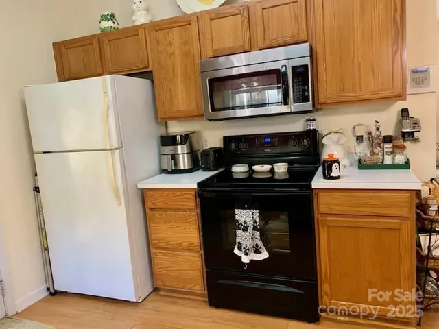 a kitchen with stainless steel appliances granite countertop a sink a stove and a wooden floors