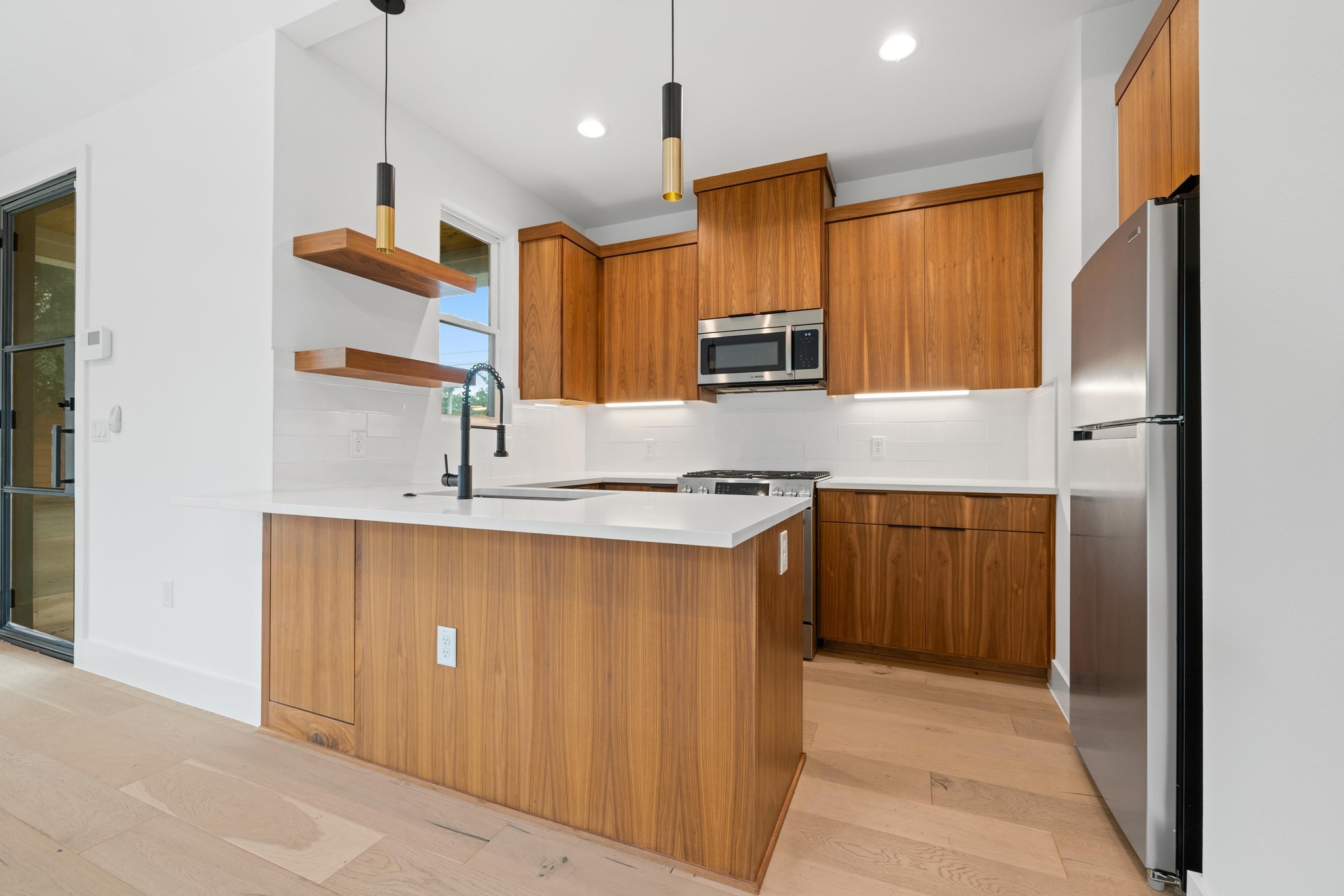 7706 Watson Street, Unit 2 Austin, TX 78757 - Photo 9 of 13 a kitchen with stainless steel appliances granite countertop a sink a stove and a refrigerator