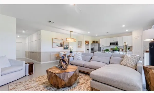a living room with furniture kitchen view and a couch