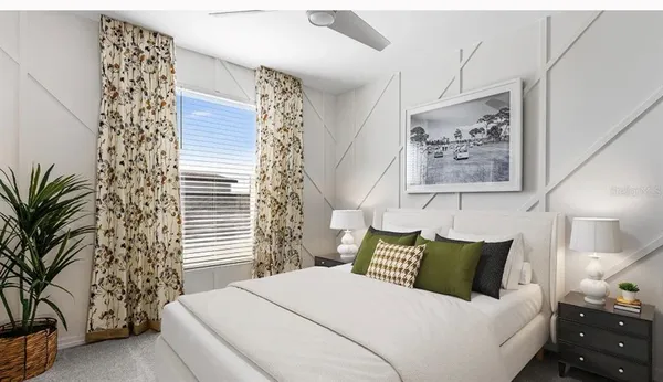 a bedroom with a bed and a potted plant