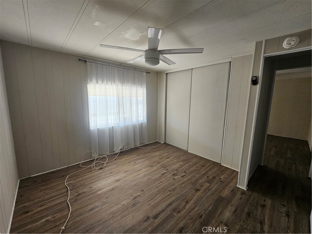 999 South Santa Fe Avenue, Unit 86 San Jacinto, CA 92583 - Photo 15 of 23 an empty room with wooden floor fan and windows