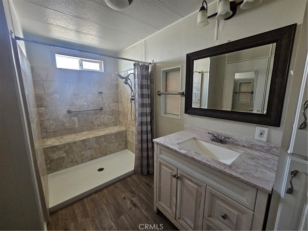 999 South Santa Fe Avenue, Unit 86 San Jacinto, CA 92583 - Photo 2 of 23 a bathroom with a granite countertop sink a mirror and shower