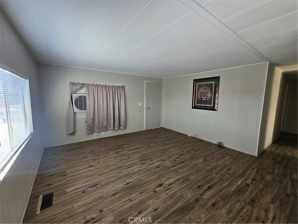 999 South Santa Fe Avenue, Unit 86 San Jacinto, CA 92583 - Photo 9 of 23 a view of an empty room with wooden floor and a window