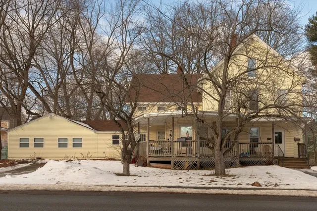 a front view of a house with a yard covered in snow
